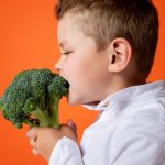 Boy in White Dress Shirt Holding Green Vegetable