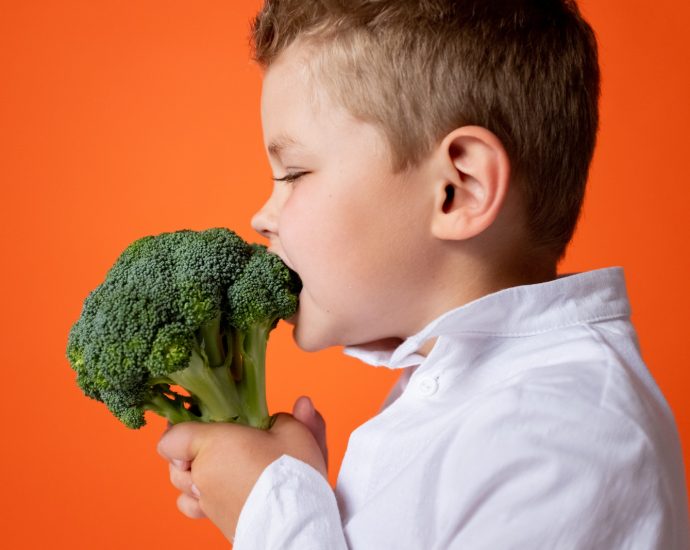 Boy in White Dress Shirt Holding Green Vegetable