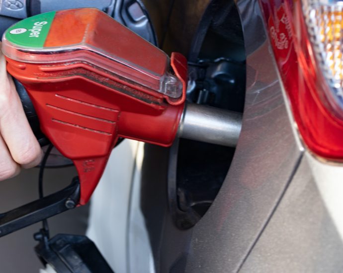 a person pumping gas into a car at a gas station