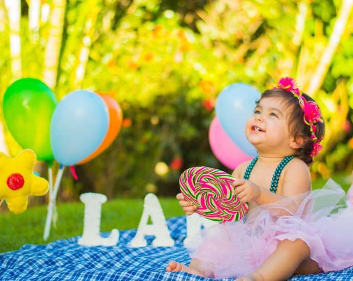 toddler looking up while holding candycane in party