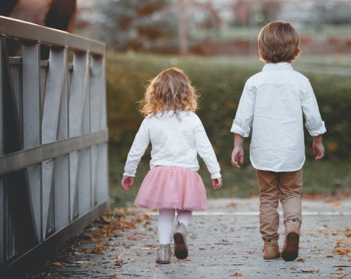 boy beside girl walking near railing