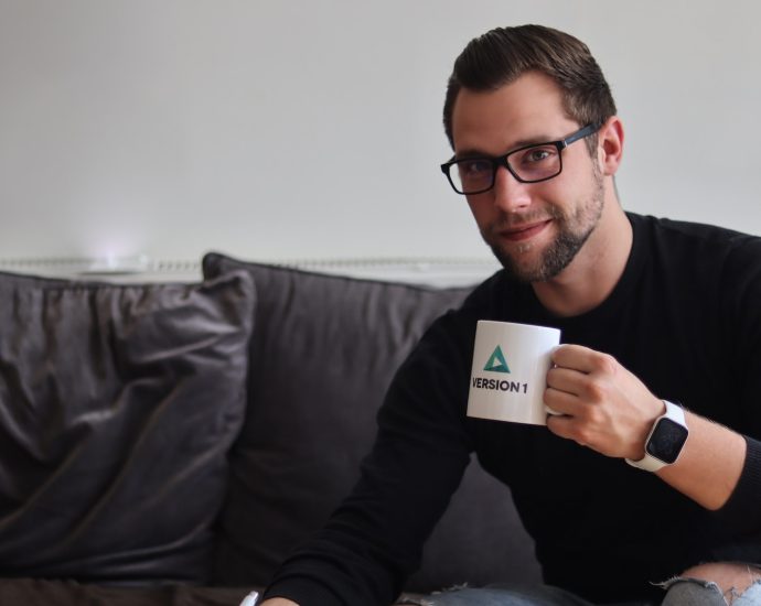 man in black long sleeve shirt holding white ceramic mug