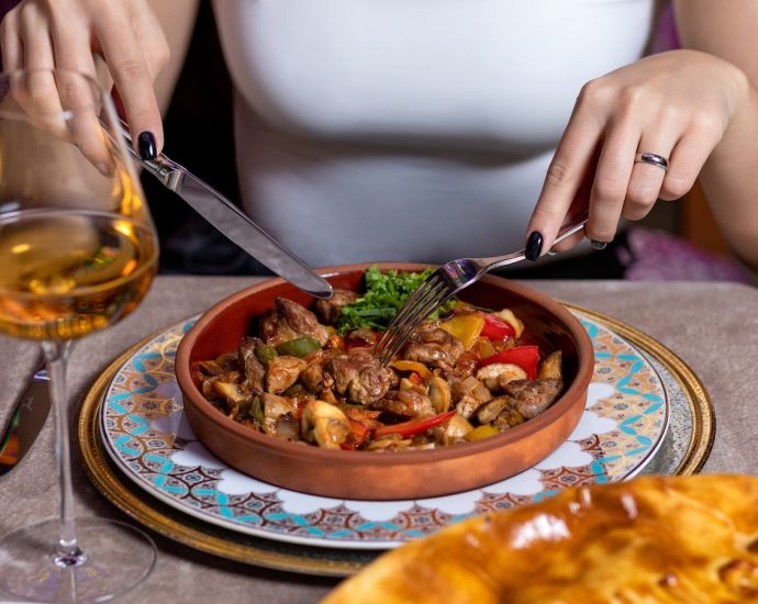 person holding stainless steel fork and knife