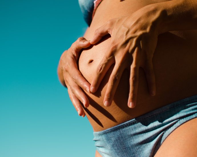 closeup photography of pregnant woman wearing blue panty