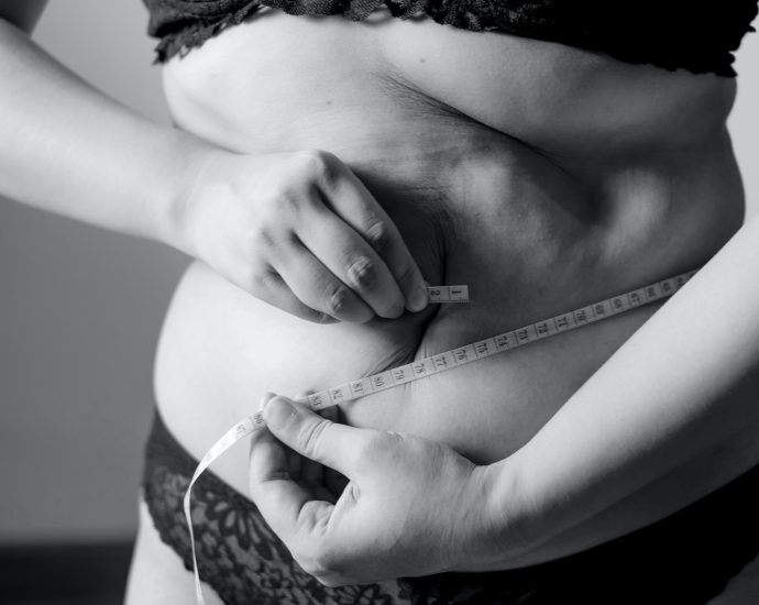 grayscale photo of woman holding her breast