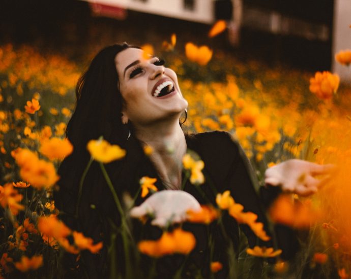 woman laughing on flower field