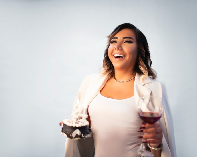 a woman holding a glass of wine and smiling