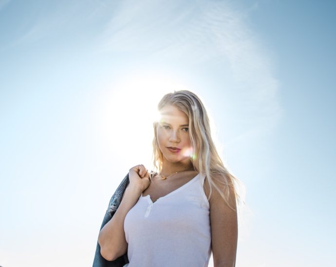 woman carrying blue jacket on her back outdoors