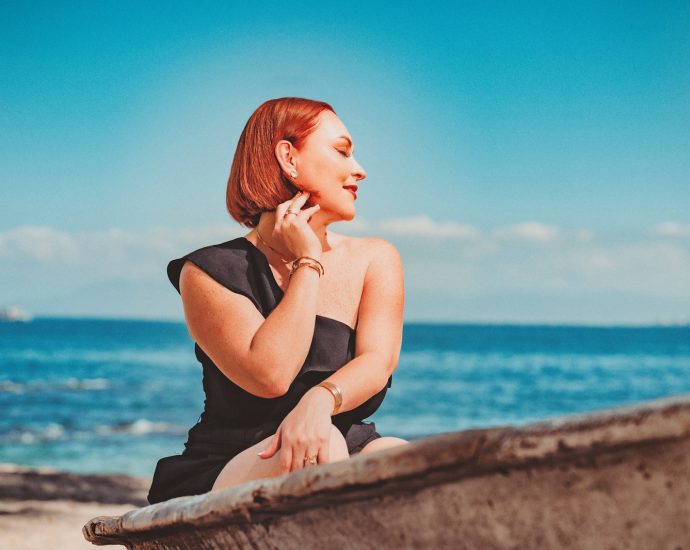 a woman sitting on a boat on the beach