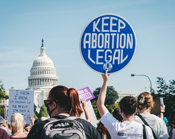 a group of people holding up signs in front of the capitol building