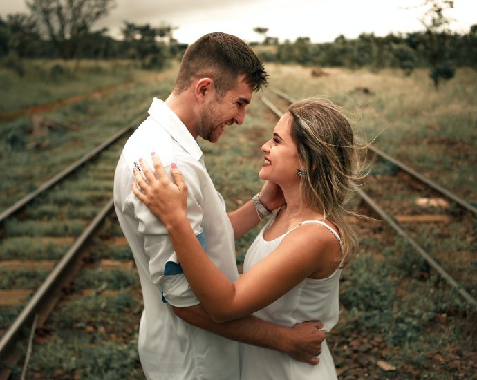 Smiling Man and Woman Facing Each Other Beside Railway Train