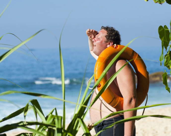 Orange Safety Ring on Man Shoulder Near Body of Water