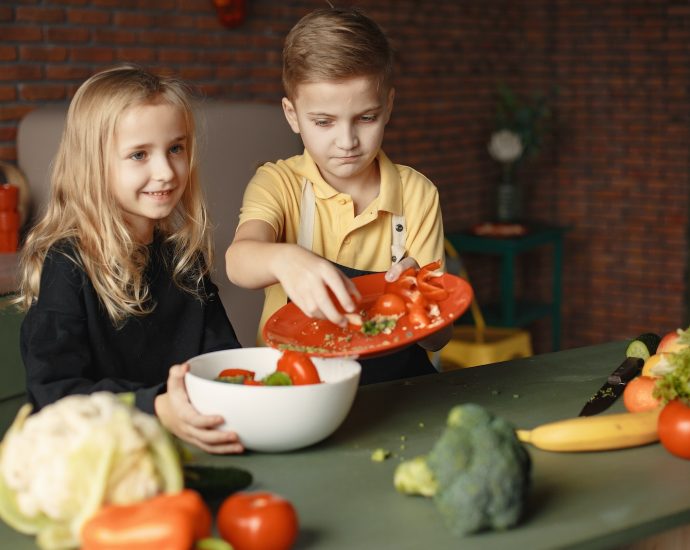 Adorable children preparing healthy salad together