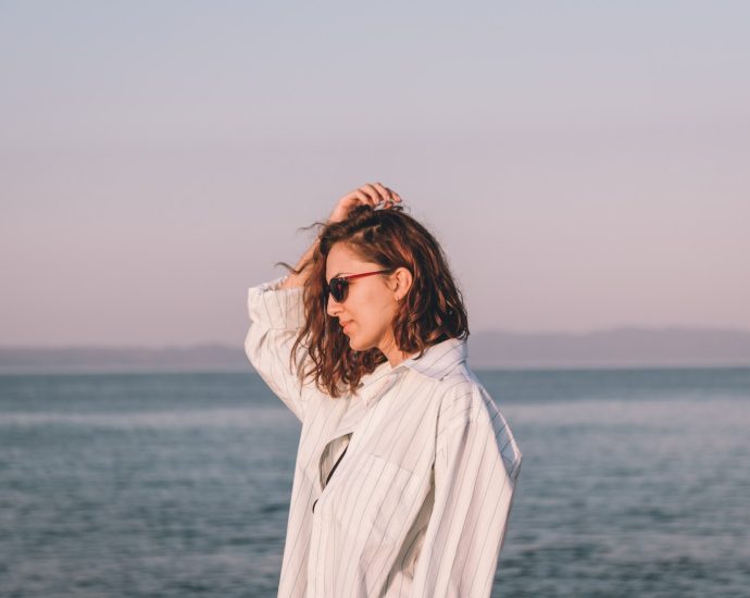 a woman standing on a beach next to the ocean