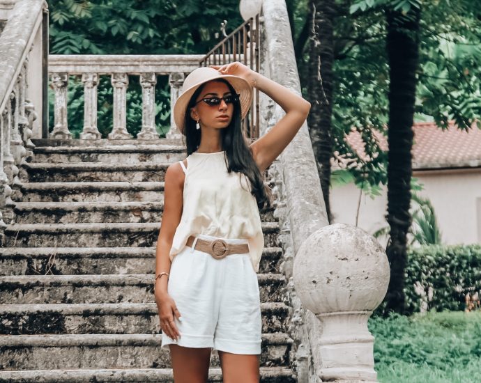 woman in white sleeveless dress standing on stairs