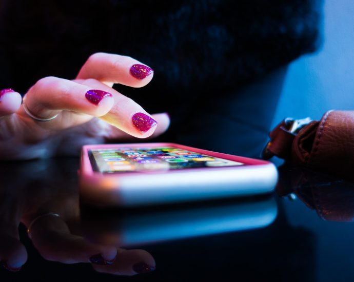 person using black smartphone with gray and pink case