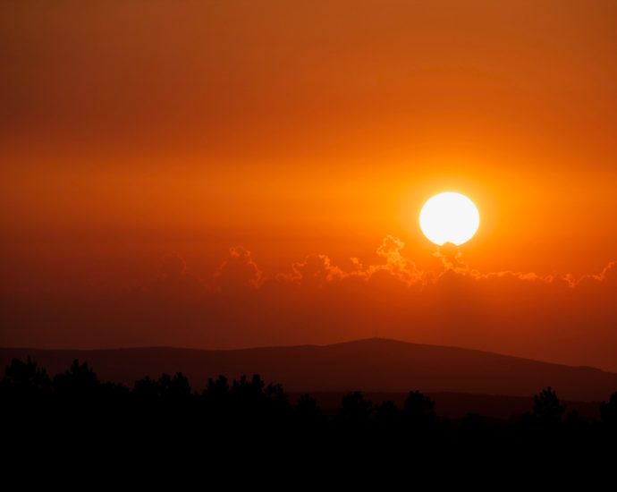 orange sunset above silhouette of mountain