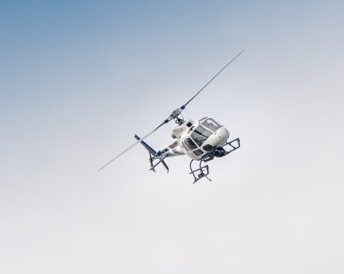 white and black drone flying under blue sky during daytime