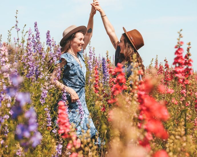 two women holding hands at the flower field