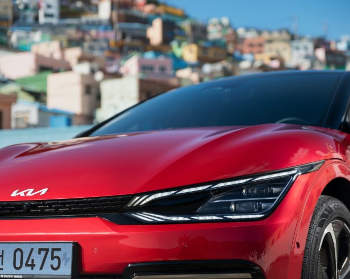 a red car parked in front of a city