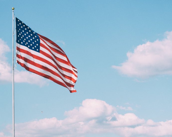 flag of U.S.A. under white clouds during daytime