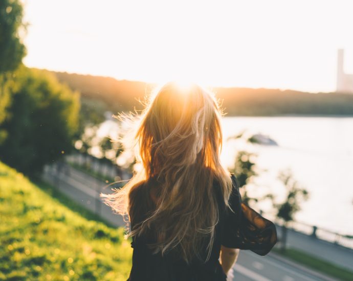 woman sitting while looking at the sunset