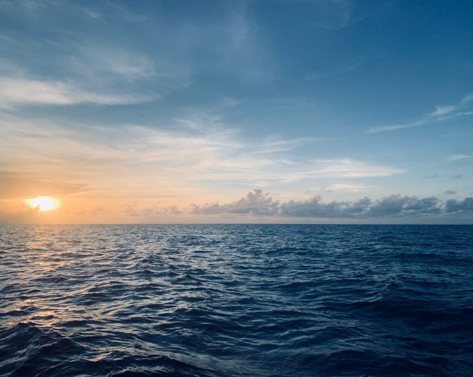 body of water under blue sky during sunset