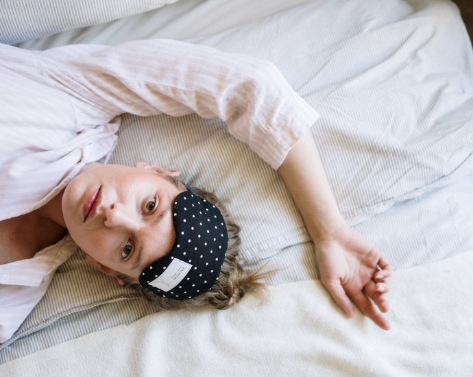 Woman in White Crew Neck T-shirt Lying on Bed