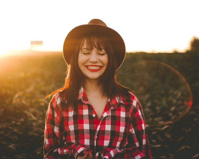 golden hour photography of woman in red and white checkered dress shirt