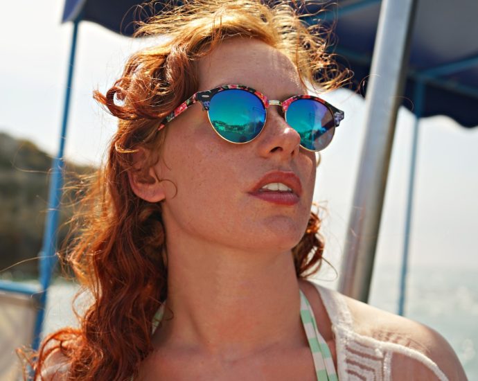 selective focus photo of woman wearing sunglasses on seashore