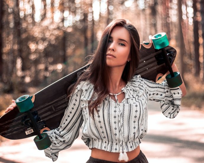 woman carrying skateboard on back