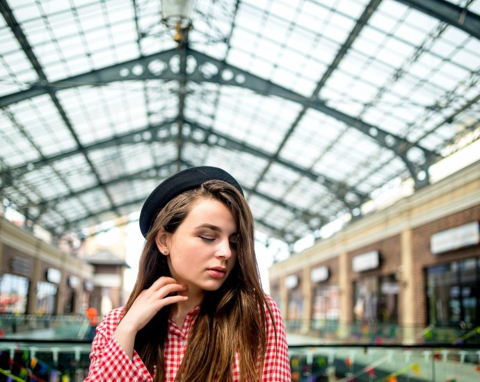 a woman in a red and white checkered shirt and a black hat