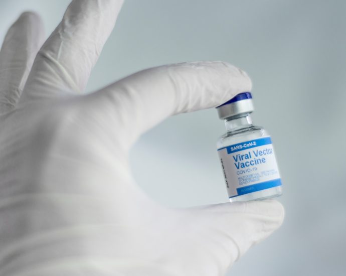 person holding white and blue labeled bottle