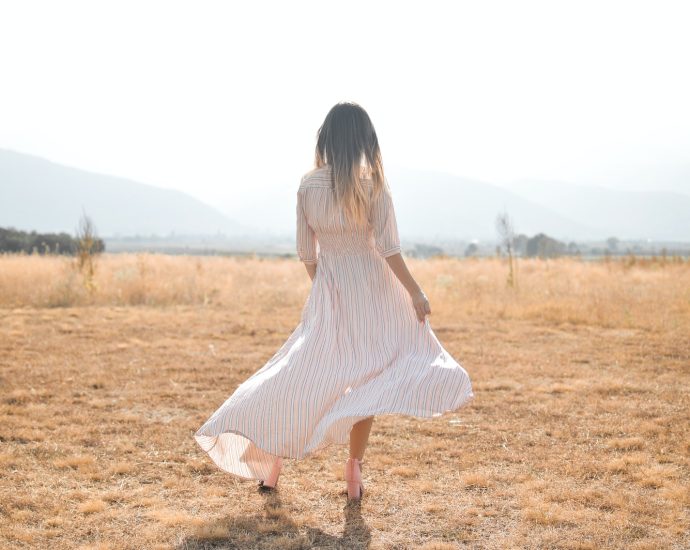 woman standing on plain brown field