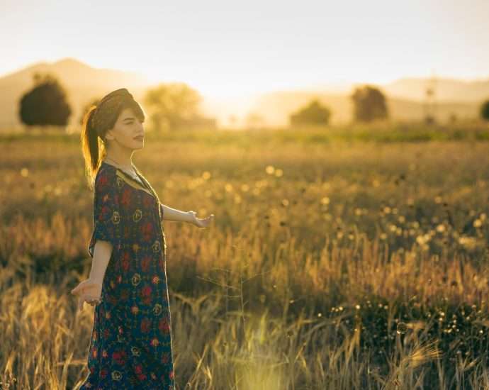 a woman standing in a field of tall grass