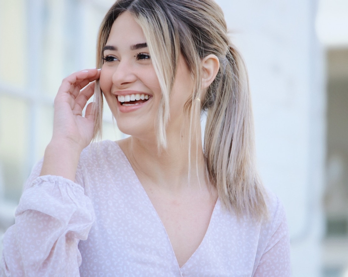 woman in white v neck long sleeve shirt smiling