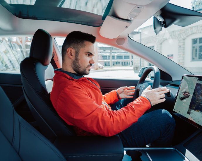 man in red long sleeve shirt driving car