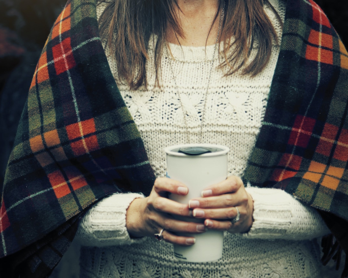 woman holding white cup