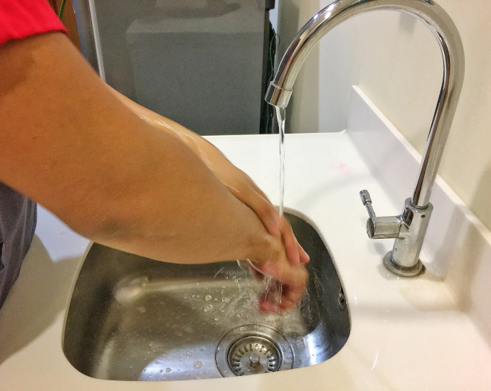 person washing hand on sink