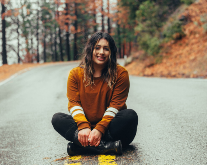 woman sitting on concrete road