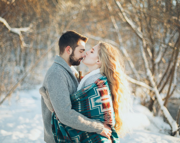 Man and Woman Hugging Each Other About to Kiss during Snow Season