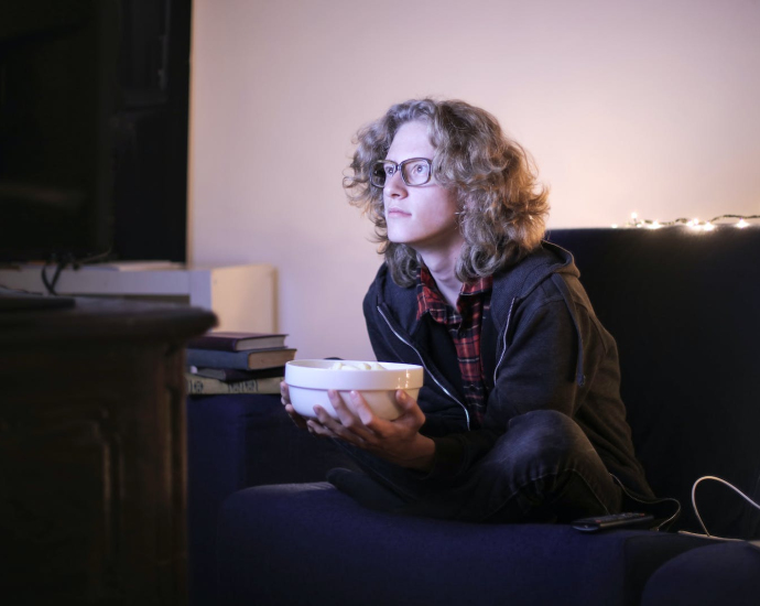 Man with a Bowl of Popcorn Watching TV at Home