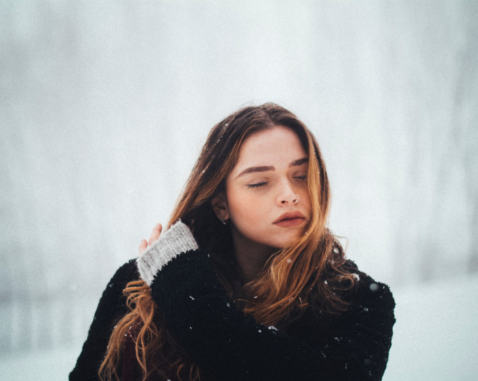 woman wearing black coat holding her hair