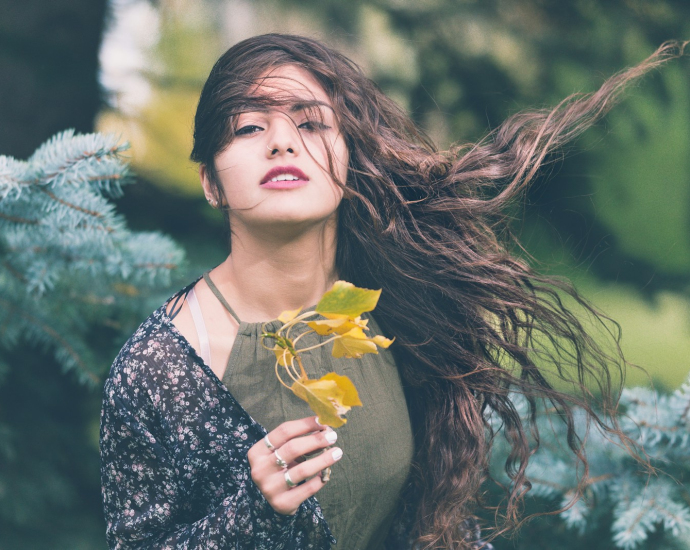 woman holding green plant in shallow focus photography