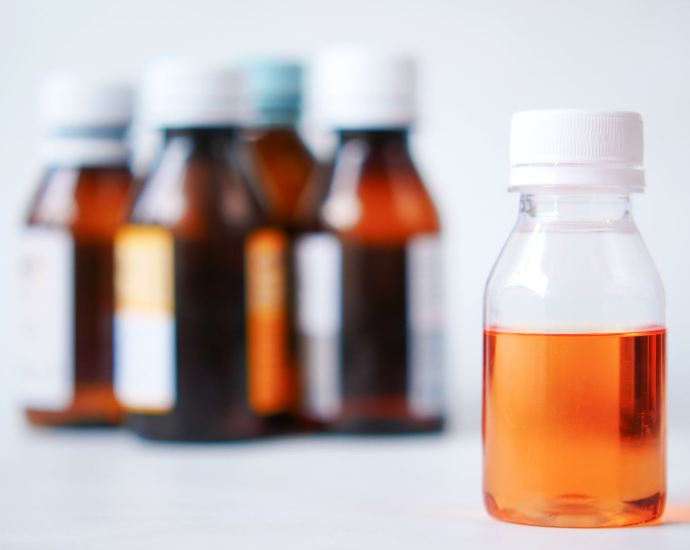 Orange and White Bottles on White Table