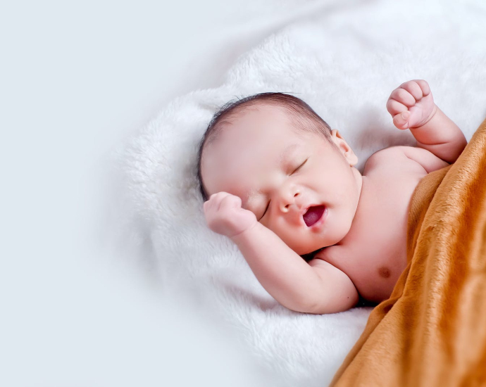 Baby Lying On White Fur With Brown Blanket