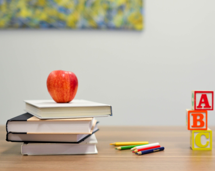 red apple fruit on four pyle books