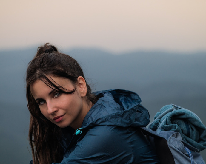 a woman in a blue jacket looking at the camera