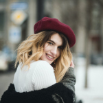 Selective Focus Photography of Smiling Woman Wearing Red Hat during Snowy Day