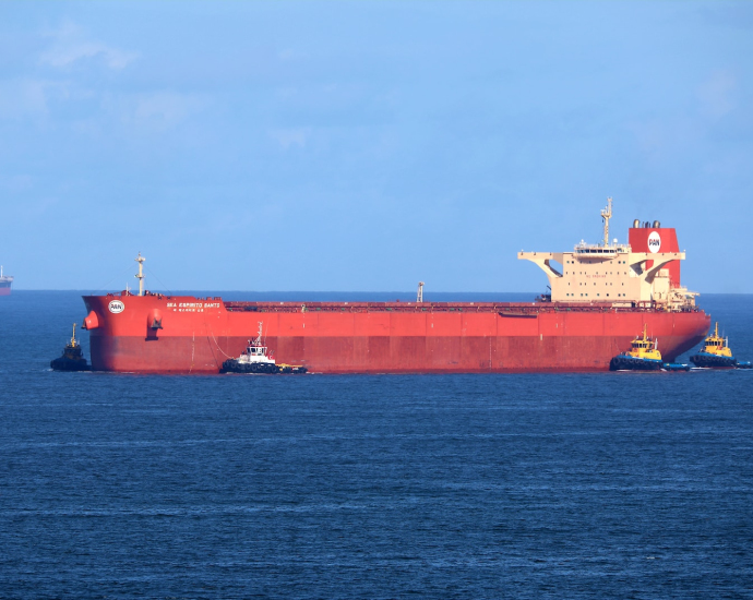 a large red cargo ship in the middle of the ocean